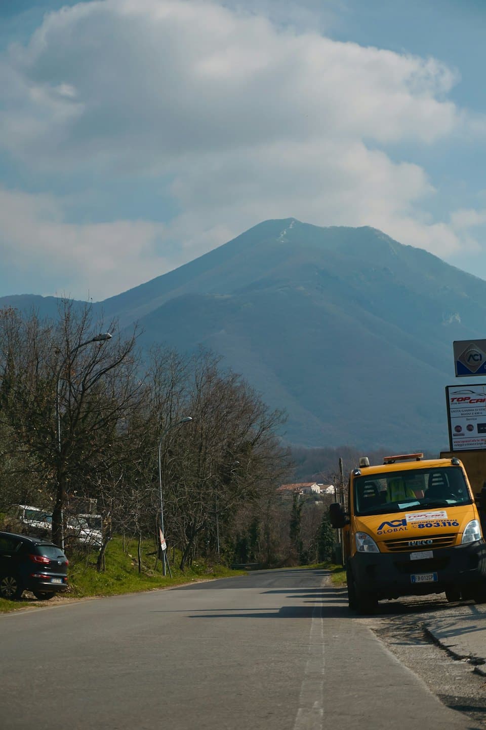 A yellow service truck parked on the side of a road.
