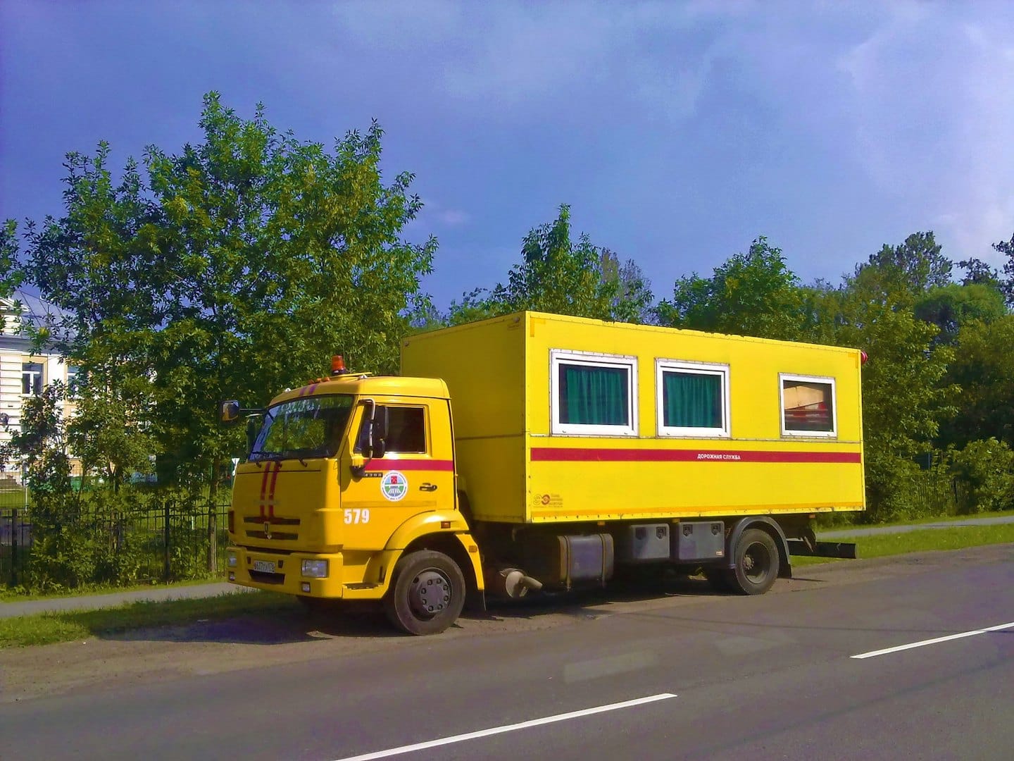 Yellow utility truck parked on the side of a road.